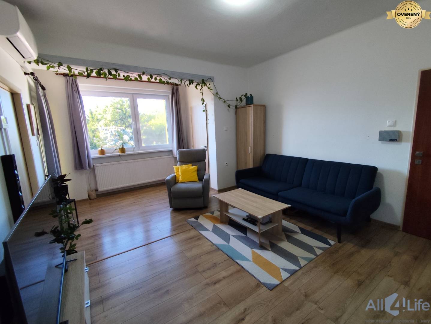 Obývacia izba rodinného domu s pohodlným sedením a podlahou s dreveným dekorom.