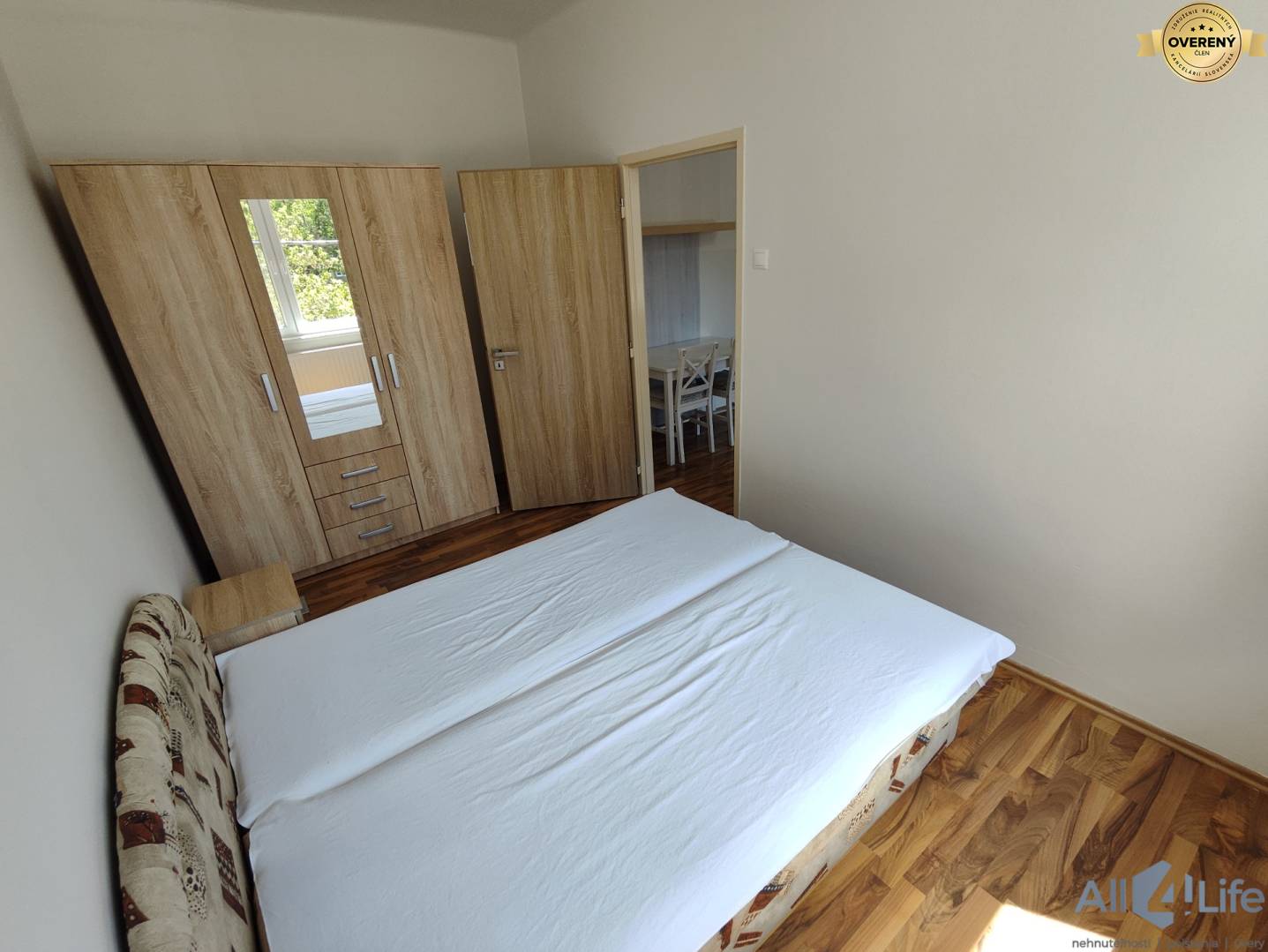 Spálňa v rodinnom dome s dreveným dekorom podlahy a šatníkovou skriňou.