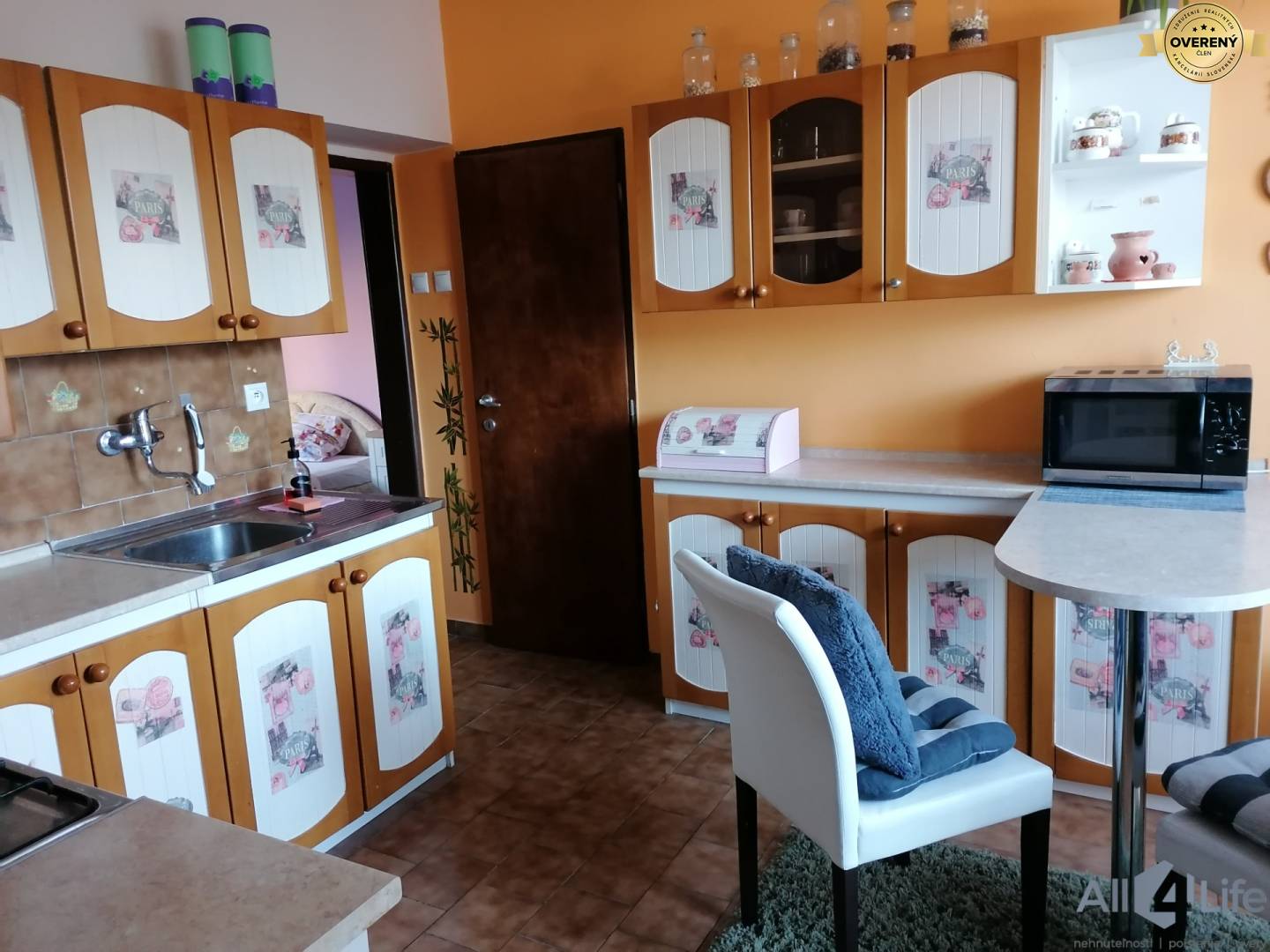 Kuchyňa v rodinnom dome s drevenými dekoratívnymi skrinkami a jedálenským barom.