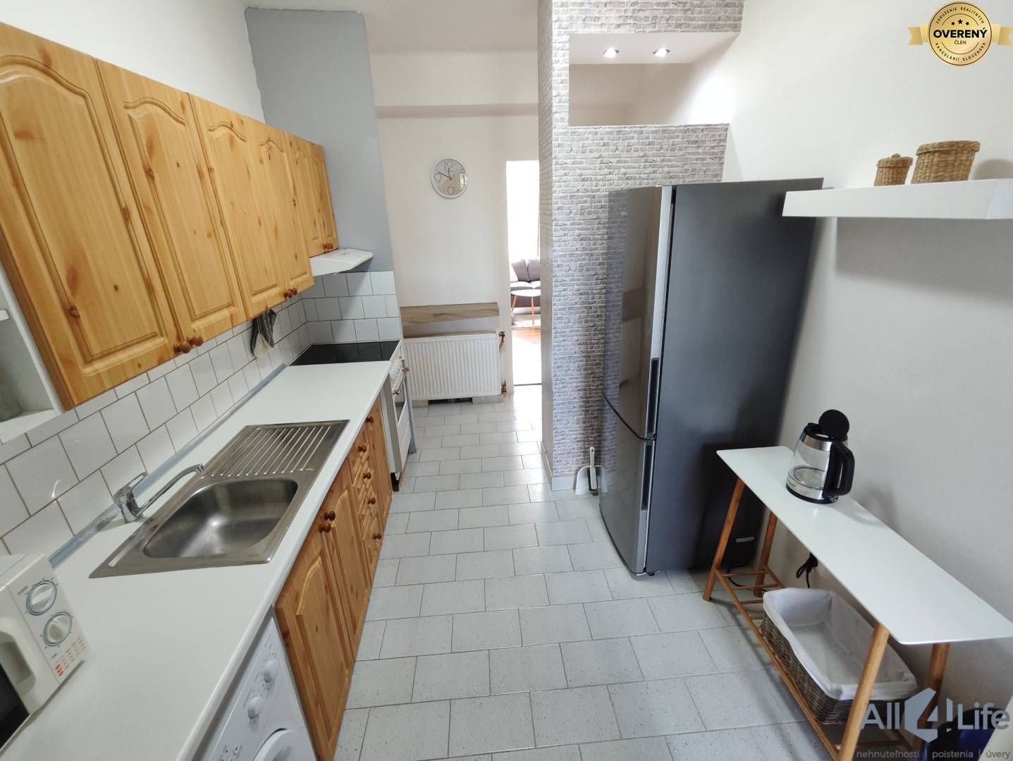 Kuchyňa v rodinnom dome so vstavanými drevenými skrinkami a modernými spotrebičmi.