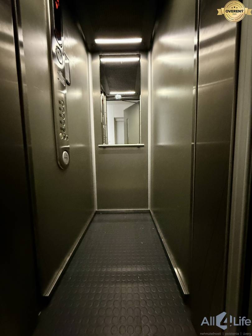 Chodba výťahu s ovládacím panelom a zrkadlom v 2-izbovom byte.
