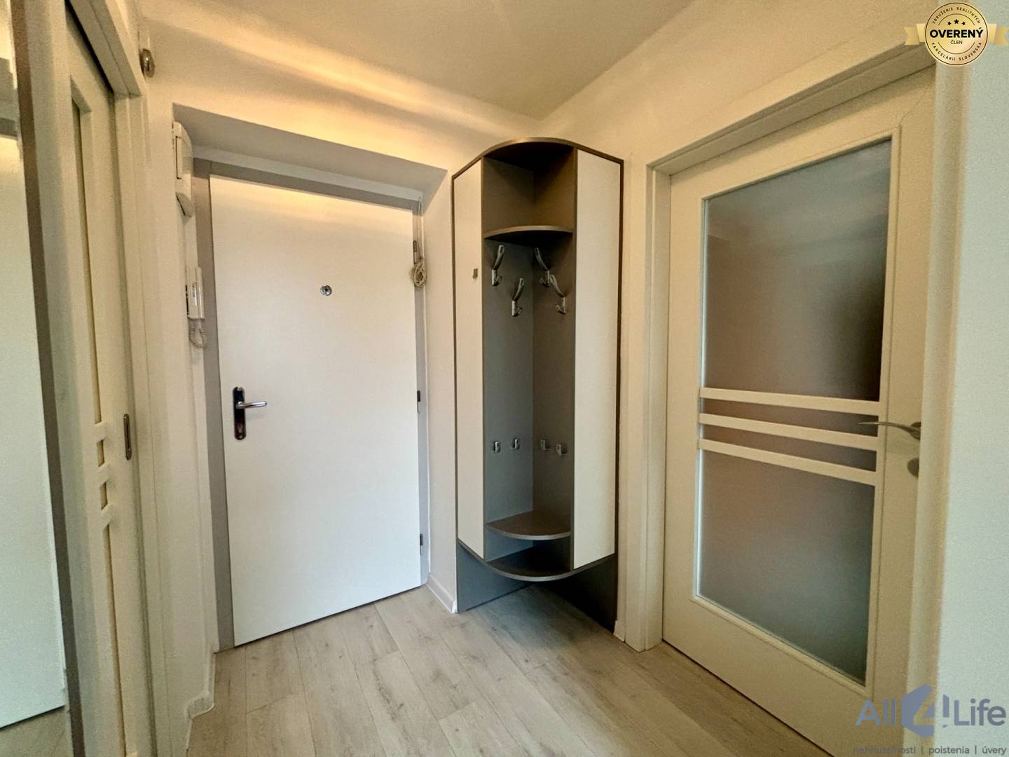 Predsieň s dverami a vstavanou skriňou v 1-izbovom byte, podlaha s dreveným dekorom.