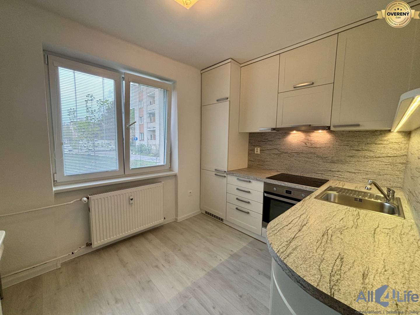 Kuchyňa v 1-izbovom byte, s podlahou s dreveným dekorom a kuchynskou linkou.